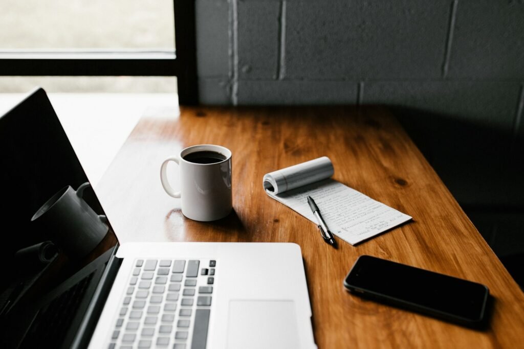 A resume and laptop on an office desk during a job application