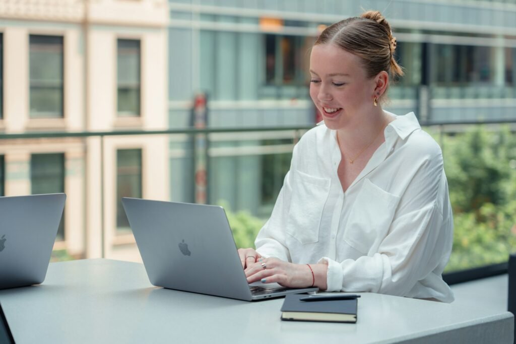 A recent graduate working on a laptop on a U.S. campus