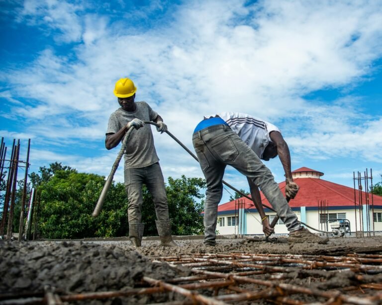 Construction workers pouring concrete on a sunny day