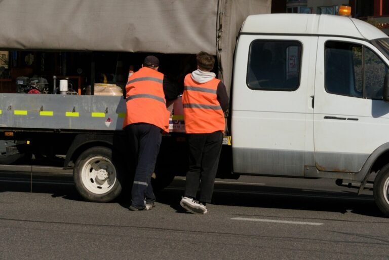 Construction crew in safety vests loading a work truck before heading to a jobsite