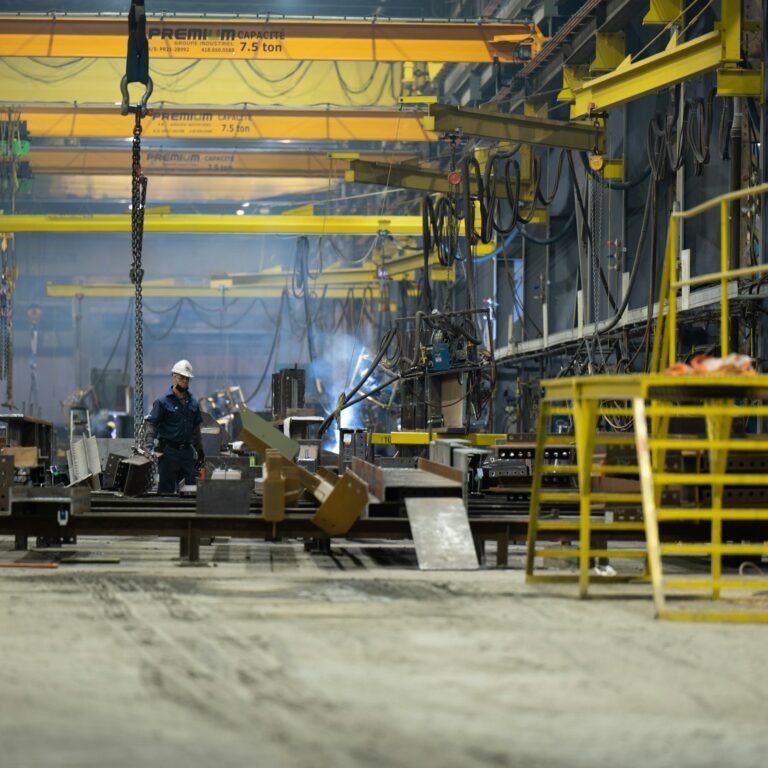 Worker welding steel inside an industrial plant under construction