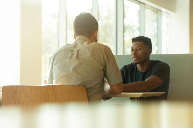 Two professionals talking across a table during a job interview